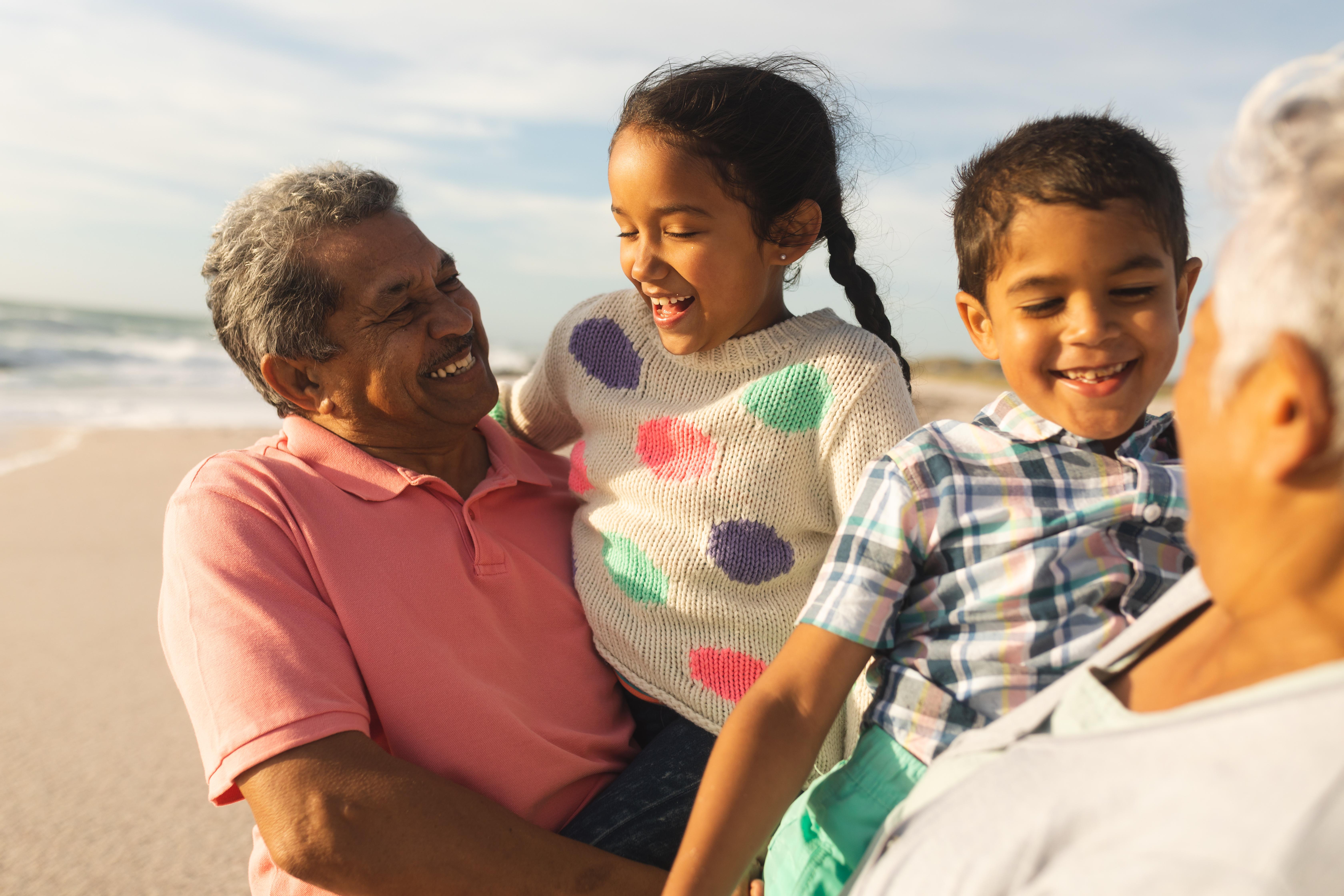 Grandparents playing with grandchildren on the beach
